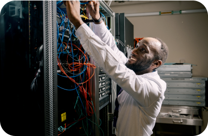 IT professional adjusting cables inside a server rack in a technical workspace.