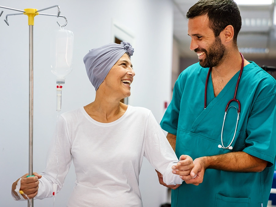 Nurse walking alongside a patient holding an IV pole in a hospital corridor, offering guidance and support.